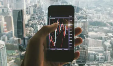 Image showing a person reviewing investment portfolios and analyzing different investment strategies on a tablet, representing the importance of understanding various investment approaches to achieve financial goals effectively.